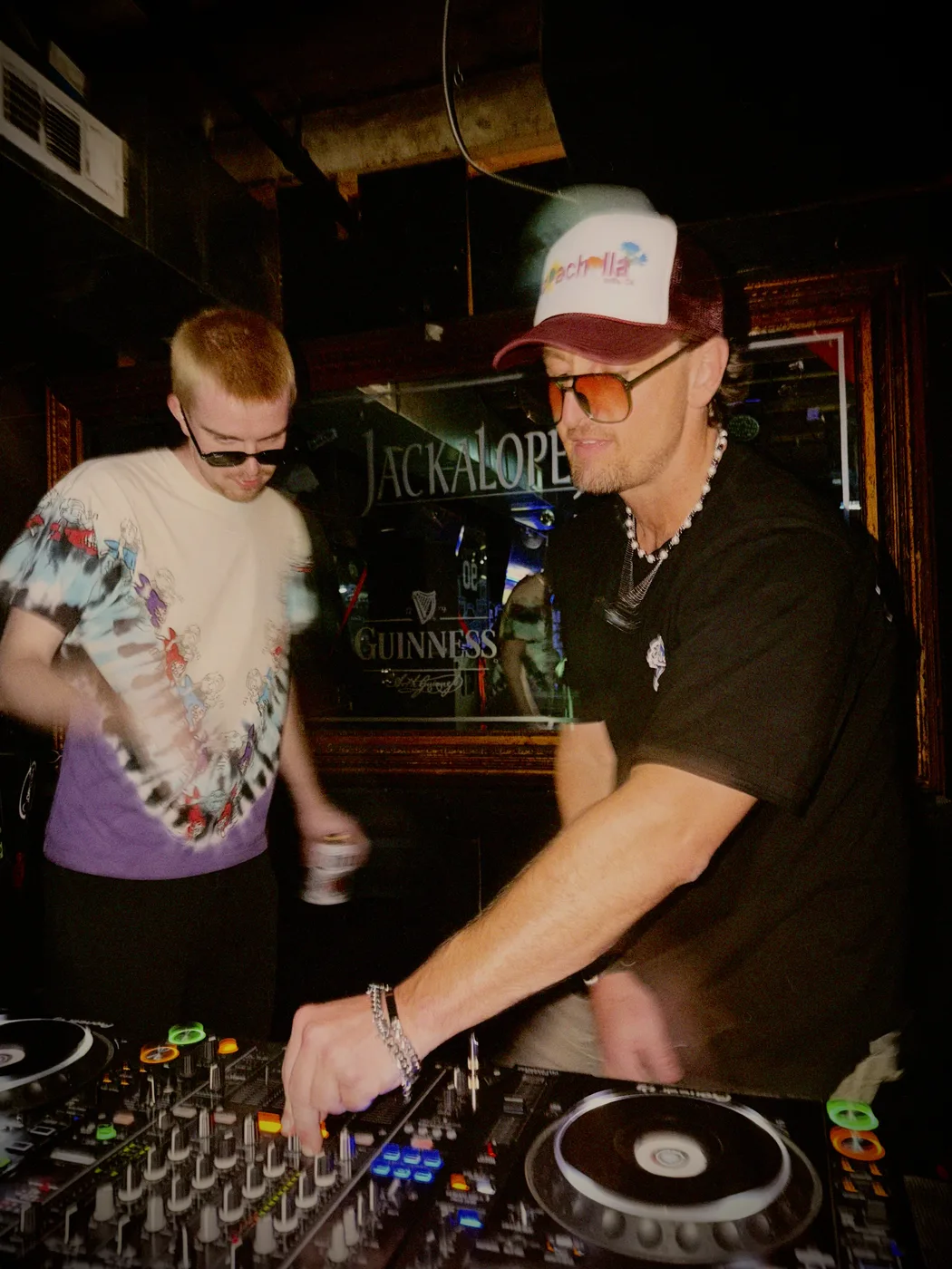 AUSTAL back to back with another DJ under neon signage